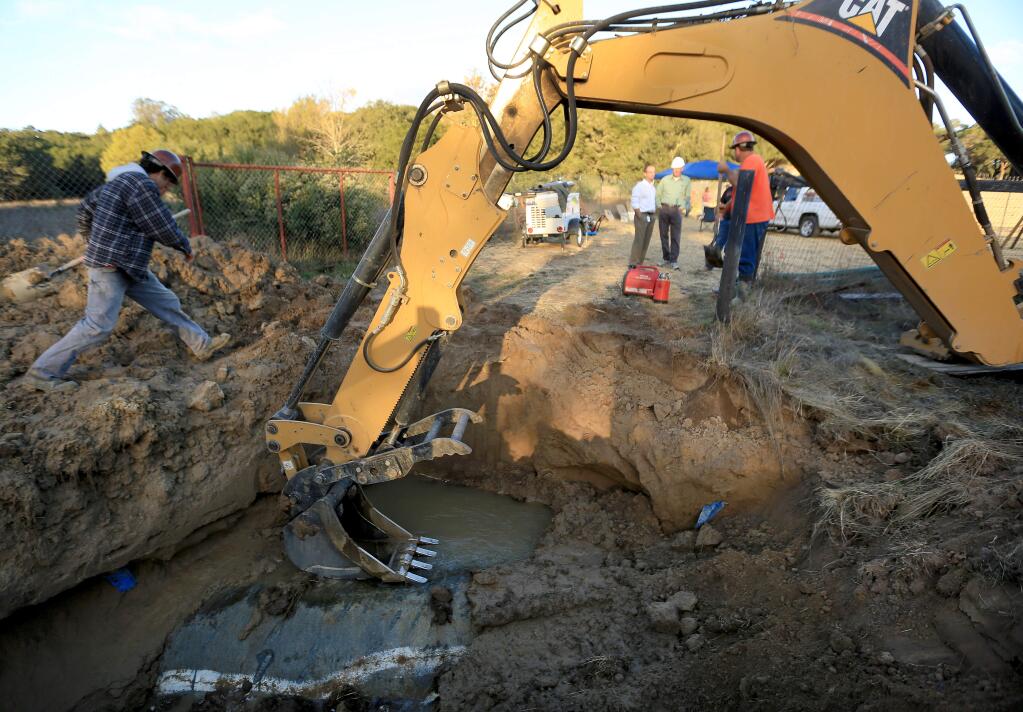 Sonoma County Water Agency workers clean up around a water main break near Forestville on Monday, Oct. 20, 2014. (KENT PORTER/ PD)