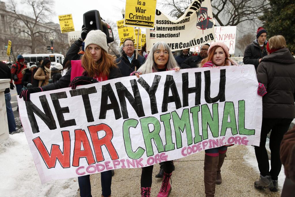 Demonstrators protesting Israeli Prime Minister Benjamin Netanyahu's speech before a joint meeting of Congress march on Capitol Hill in Washington, Tuesday, March 3, 2015. Netanyahu is using the address to Congress to warn against trusting Iran to curb its nuclear ambitions. (AP Photo/Andrew Harnik)