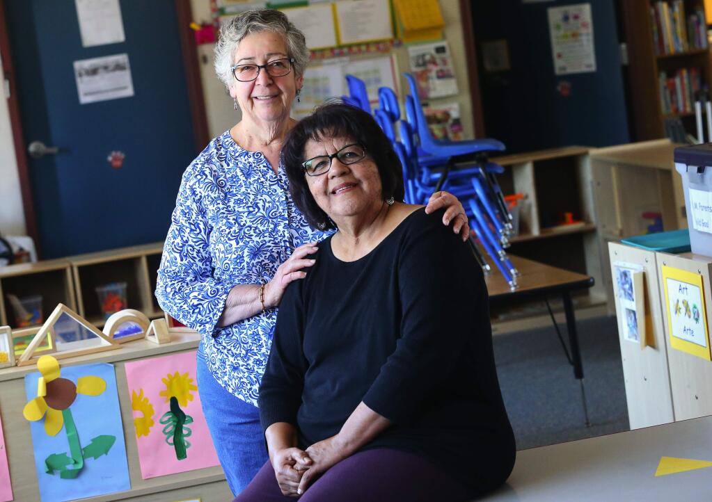 Rosalba Ramos, left, was a parent volunteer when Esther Lemus was the center director of Head Start at Wright Elementary School in 1985. Now, Ramos is the center director of Head Start at Robert L. Stevens School and Lemus is her volunteer.(Christopher Chung/ The Press Democrat)