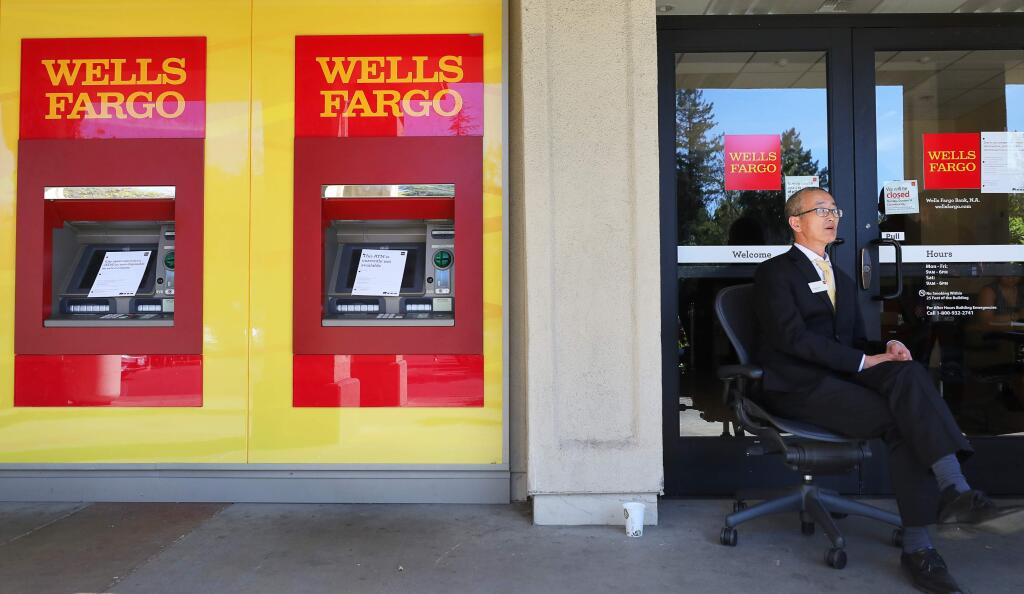 Joce Richmond, a Wells Fargo personal banker, sits outside the branch at Fourth Street, in Santa Rosa, to help customers during the power shutdown on Thursday, October 10, 2019. The branch was allowing customers to enter one at a time and offered limited transactions. (Christopher Chung/ The Press Democrat)