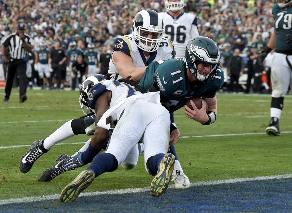 Philadelphia Eagles quarterback Carson Wentz gets tackled during the second half against the Los Angeles Rams Sunday, Dec. 10, 2017, in Los Angeles. Wentz left the game shortly after the play and did not return to the game. (AP Photo/Mark J. Terrill)