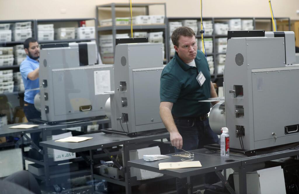 Employees at the Broward County Supervisor of Elections office clean machines during a break in sorting ballots, Tuesday, Nov. 13, 2018, in Lauderhill, Fla. (AP Photo/Wilfredo Lee)