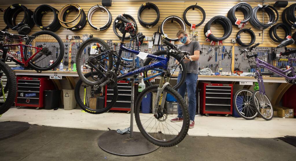 Bike Peddler store manager Chris Wells does a final check on a mountain bike before completing a sale to a customer in Santa Rosa on Monday. (Photo by John Burgess/The Press Democrat)