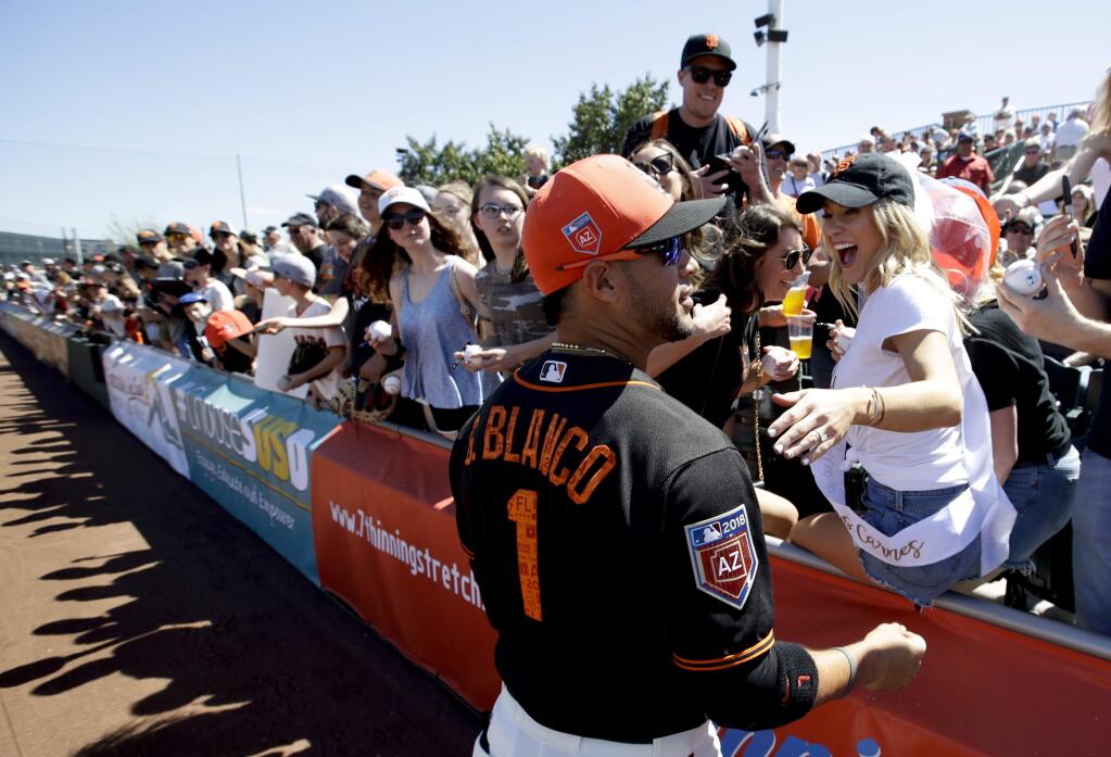 Jackie Jeffus, front right, of Santa Monica, gets an autograph from San Francisco Giants right fielder Gregor Blanco before a spring training game against the Kansas City Royals in Scottsdale, Ariz., Friday, March 23, 2018. (AP Photo/Chris Carlson)