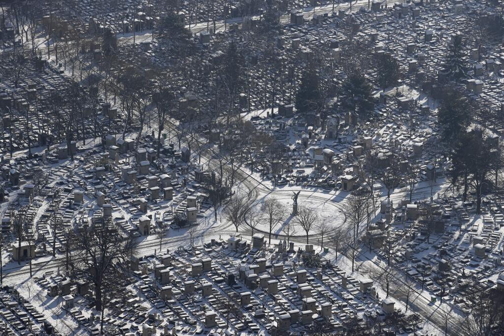 Snow covers the Montparnasse cemetery in Paris, Thursday, Feb.8, 2018. Heavy snowfall has caused travel disruptions in the northern half of France and in Paris as the weather conditions caught authorities off guard. (AP Photo/Francois Mori)