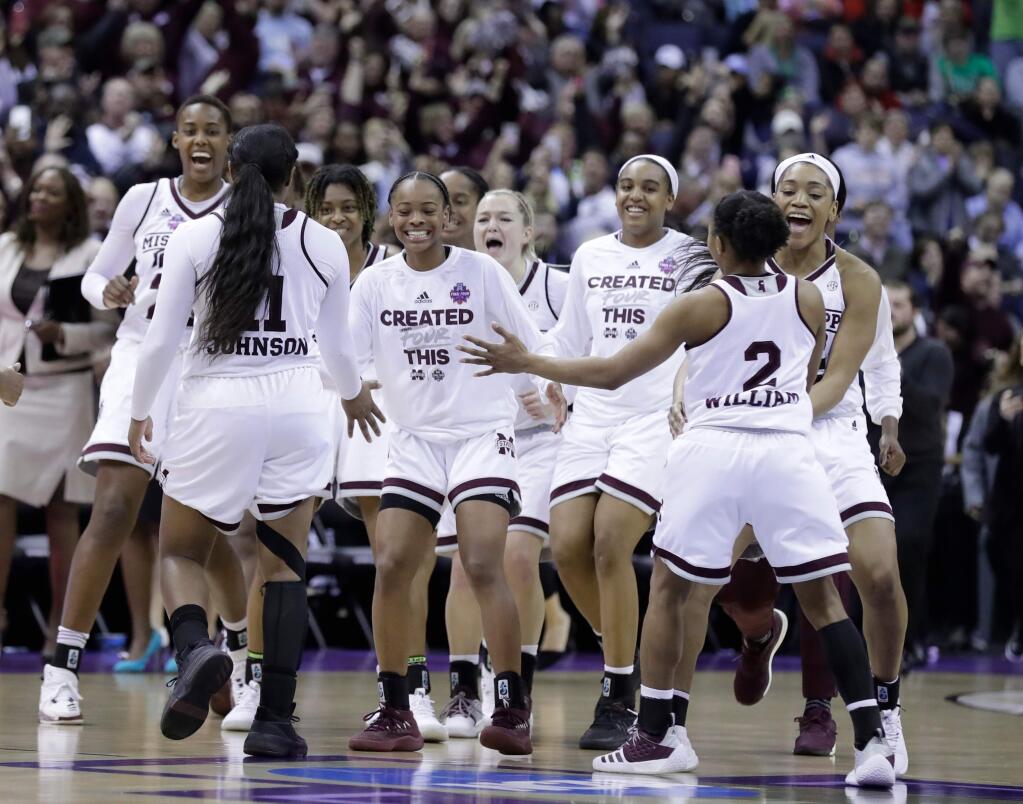 Members of Mississippi State celebrate after defeating Louisville in the semifinals of the women's NCAA Final Four, Friday, March 30, 2018, in Columbus, Ohio. Mississippi State won 73-63. (AP Photo/Ron Schwane)