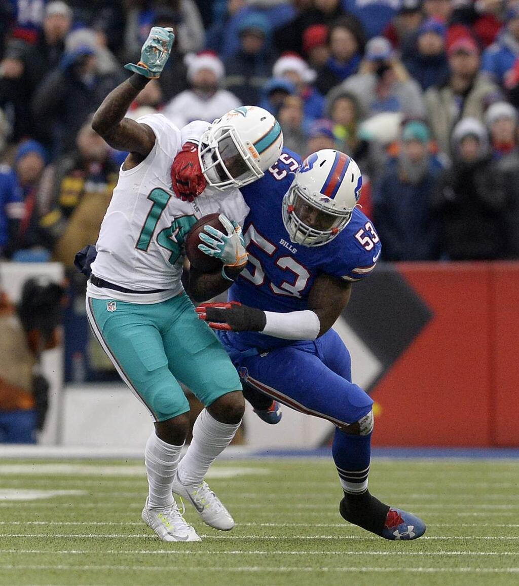 Miami Dolphins wide receiver Jarvis Landry (14) is tackled by Buffalo Bills linebacker Zach Brown (53) during the first half Saturday, Dec. 24, 2016, in Orchard Park, N.Y. (AP Photo/Adrian Kraus)
