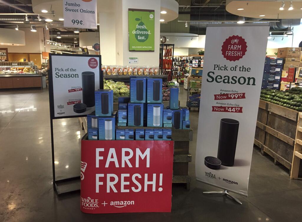 FILE - In this Monday, Aug. 28, 2017, file photo, Amazon's Echo and Echo Dot appear on sale at a Whole Foods Market in New York. You may see more of Amazon inside Whole Foods soon: The online retailer, which has been already been selling its voice-activated Echos at Whole Foods, will start to sell Kindles, Fire tablets and other Amazon devices at its grocery stores. (AP Photo/Joseph Pisani, File)