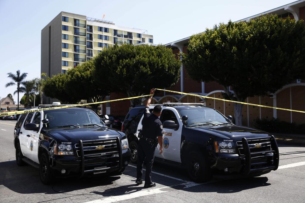 FILE - In this June 25, 2018 file photo, Long Beach police keep a street closed off near a retirement home, seen in background in Long Beach, Calif. Thomas Kim, 77, charged with shooting to death a fire captain at the Southern California senior housing facility has died Sunday, Aug. 5, 2018, in custody from an existing medical condition, authorities said Monday, Aug. 6. Kim was charged with murder for the death of Capt. David Rosa on June 25 at Covenant Manor, an 11-story senior apartment complex. (AP Photo/Jae C. Hong, File)