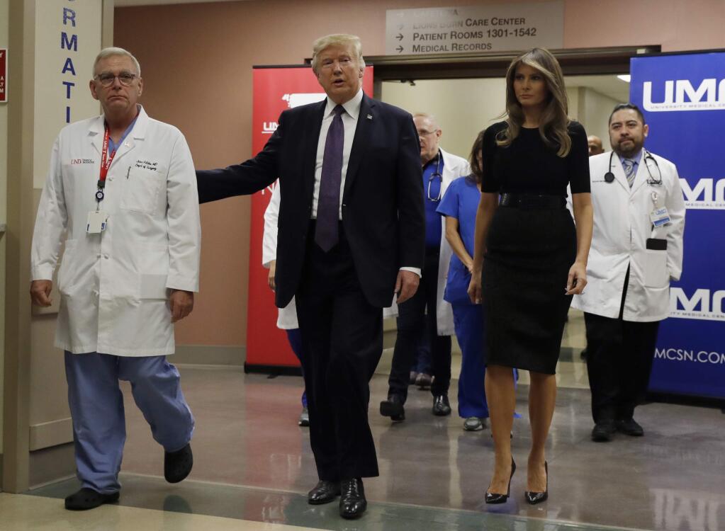 President Donald Trump and first lady Melania Trump walk with surgeon Dr. John Fildes at the University Medical Center after meeting with victims of the mass shooting Wednesday, Oct. 4, 2017, in Las Vegas. (AP Photo/Evan Vucci)