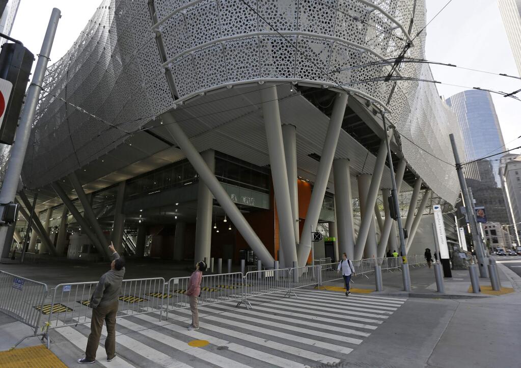 FILE - In this Sept. 27, 2018, file photo, people stop to look at the closed Salesforce Transit Center in San Francisco. (AP Photo/Eric Risberg, File)