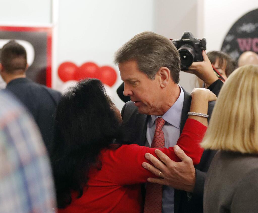 Georgia Republican gubernatorial candidate Brian Kemp greets supporters during a stop at a campaign office Monday, Nov. 5, 2018, in Atlanta. Kemp is in a close race with Democrat Stacey Abrams. (AP Photo/John Bazemore)