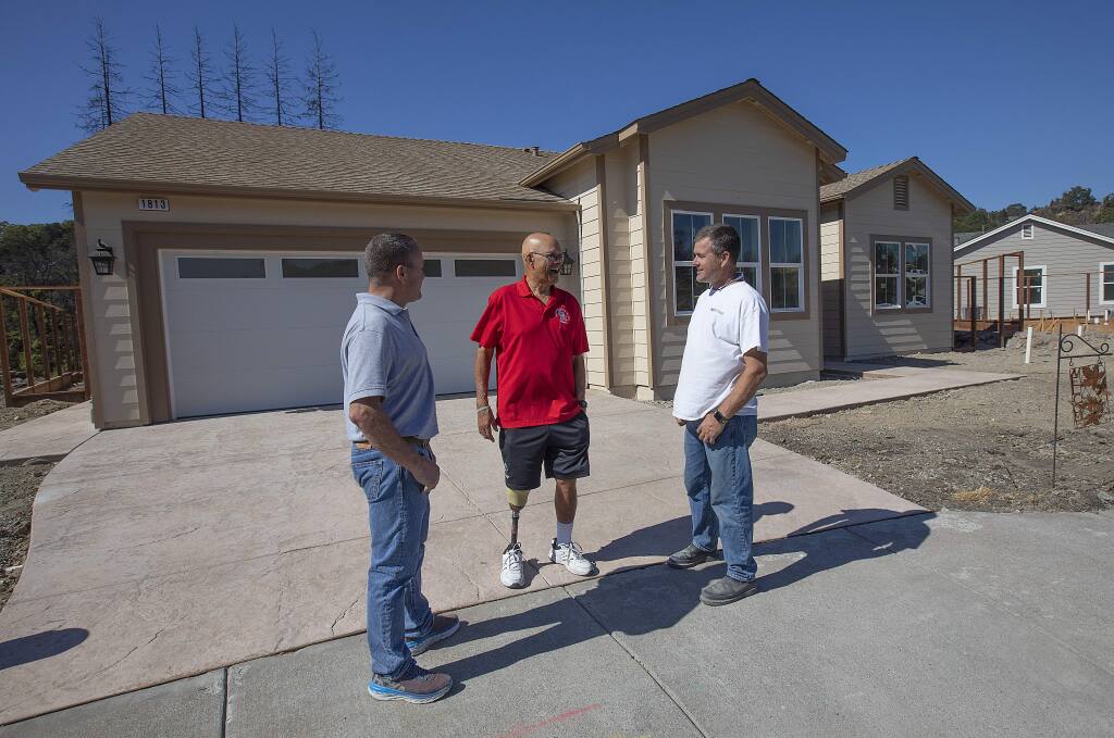 Homeowner Tom Francois, center, talks with Dave, right, and Eric Keith of Sonoma County builders in front of his rebuilt home, the first to be completed in Fountaingrove, on Sonterra Ct. (photo by John Burgess/The Press Democrat)