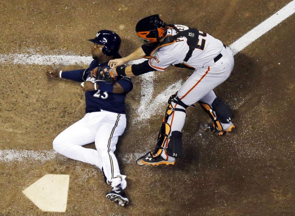San Francisco Giants catcher Buster Posey tags out Milwaukee Brewers' Rickie Weeks at home during the seventh inning of a baseball game Wednesday, Aug. 6, 2014, in Milwaukee. Weeks tried to score from third on a ball hit by Ryan Braun. (AP Photo/Morry Gash)