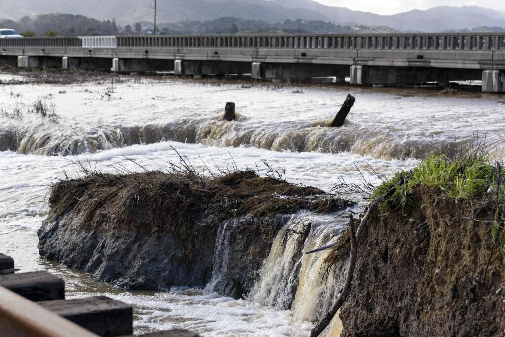Water from recent heavy rain storms breeches a levee in Novato, Calif., Thursday, Feb. 14, 2019. Waves of heavy rain pounded California on Thursday, flooding streets, triggering a mudslide that destroyed homes and forcing residents to flee communities scorched by wildfires last year. (AP Photo/Michael Short)
