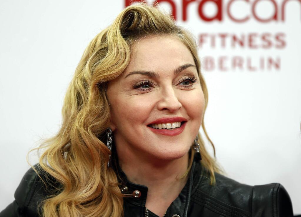 FILE - In this Thursday, Oct. 17, 2013, file photo, U.S. pop star Madonna smiles during her visit at the 'Hard Candy Fitness' center in Berlin. Madonna, AC/DC and Ariana Grande are among the first performers set to take the stage at the Grammy Awards on Feb. 8, 2015, in Los Angeles. (AP Photo/Michael Sohn, File)