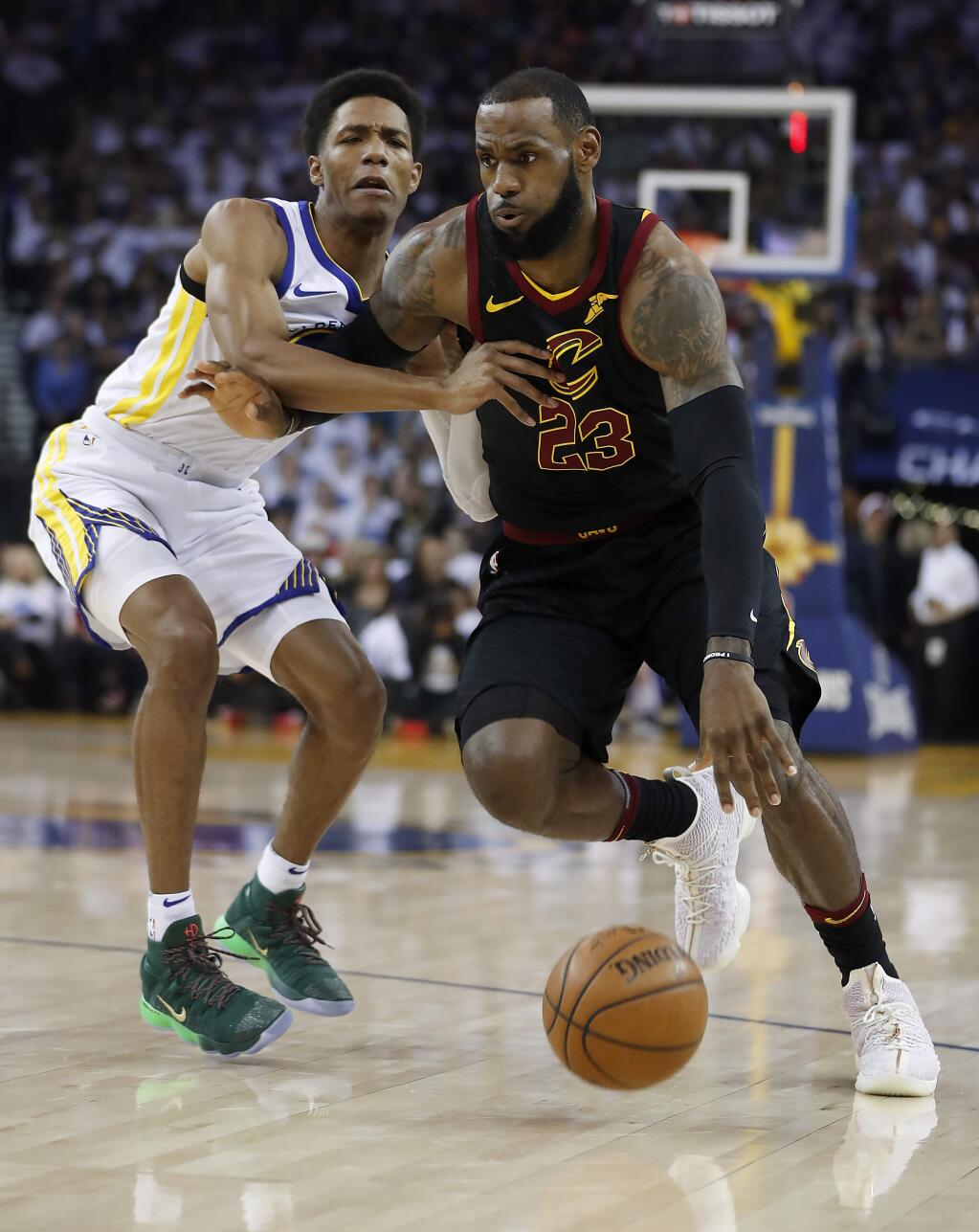 Cleveland Cavaliers forward LeBron James (23) drives to the basket past Golden State Warriors guard Patrick McCaw during the first half of an NBA basketball game in Oakland, Calif., Monday, Dec. 25, 2017. (AP Photo/Tony Avelar)