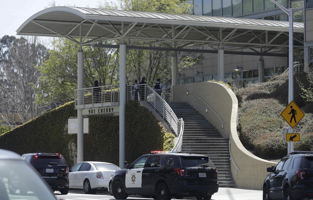 Officers stand by an entrance at the YouTube complex in San Bruno, Calif., Tuesday, April 3, 2018. A woman opened fire at YouTube headquarters Tuesday, setting off a panic among employees and wounding several people before fatally shooting herself, police and witnesses said. (AP Photo/Jeff Chiu)