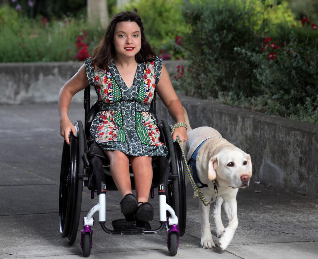 Olivia Ellis of Windsor, enters with her service dog, 'Rae Lynn' during the Canine Companions' annual Sit Stay Sparkle event in Santa Rosa, on Saturday, June 15, 2019. (Darryl Bush / For The Press Democrat)