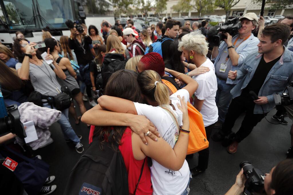 Students from Stoneman Douglas High School, hug survivors of the Pulse nightclub shooting before boarding buses in Parkland, Fla., Tuesday, Feb. 20, 2018. The students plan to hold a rally Wednesday in hopes that it will put pressure on the state's Republican-controlled Legislature to consider a sweeping package of gun-control laws, something some GOP lawmakers said Monday they would consider.