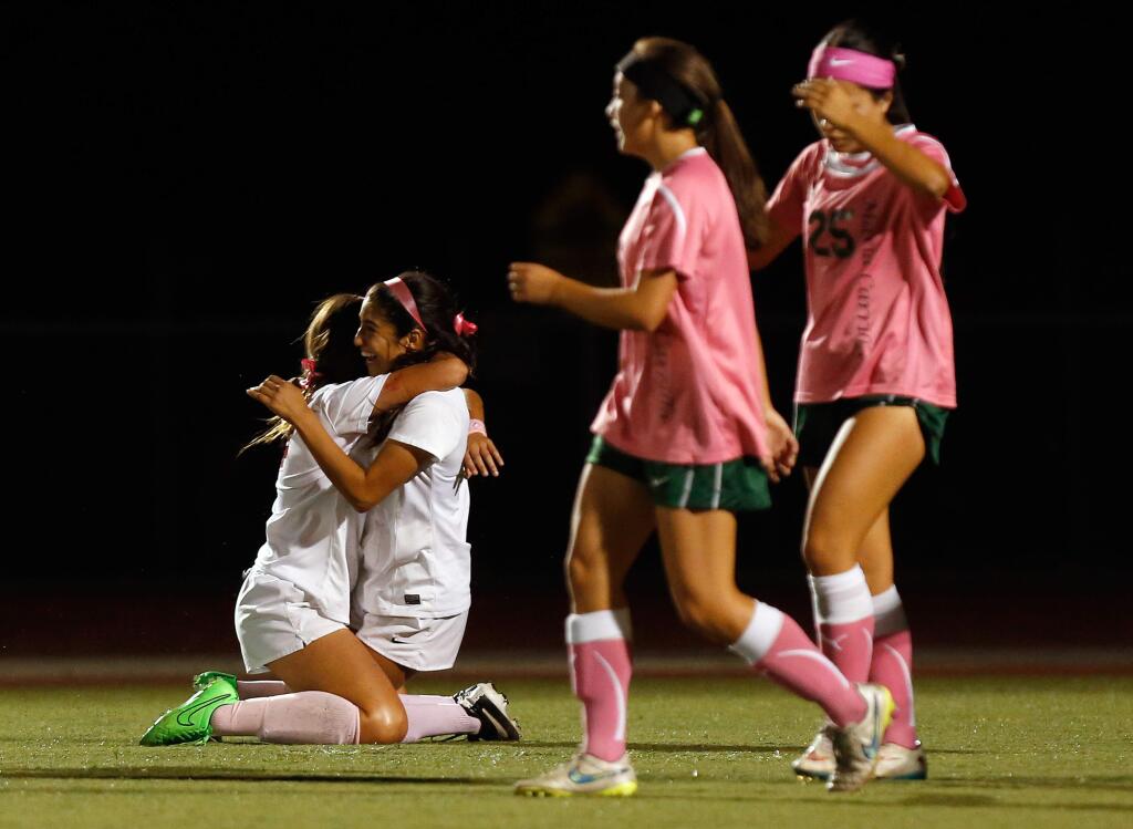 Montgomery's Cindy Arteaga (14), left, embraces Gabby Rodriguez (2) after Rodriguez scored a game-tying goal in the first half of a girls varsity soccer match in Santa Rosa, California on Thursday, October 8, 2015. (Alvin Jornada / The Press Democrat)