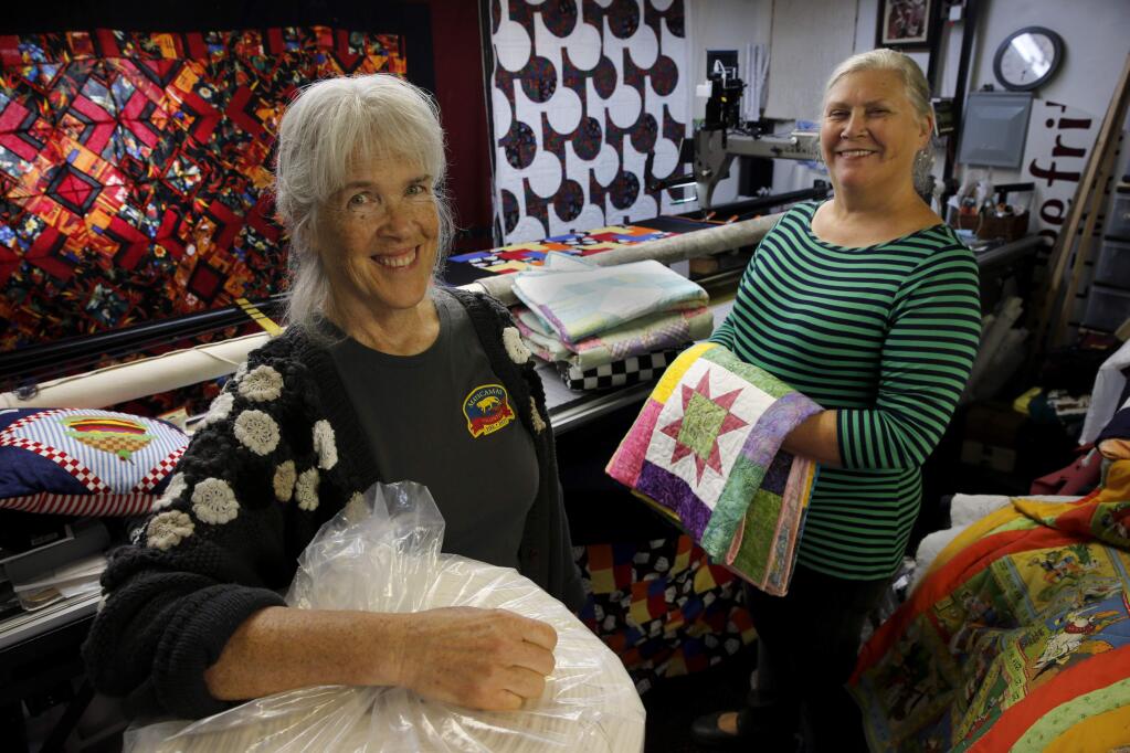 Laura Lee Fritz, left, and Mary Chelton, who are members of a group called the 'Happiness is A Warm Quilt', stand in Fritz's quilting studio on Monday, November 13, 2017 in Sonoma, California . (BETH SCHLANKER/The Press Democrat)