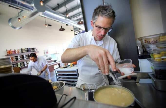 Mark Hopper, owner and chef at Vignette Pizzeria in Sebastopol, puts salt in his casserole made from earthquake kit ingredients. (CHRISTOPHER CHUNG / The Press Democrat)