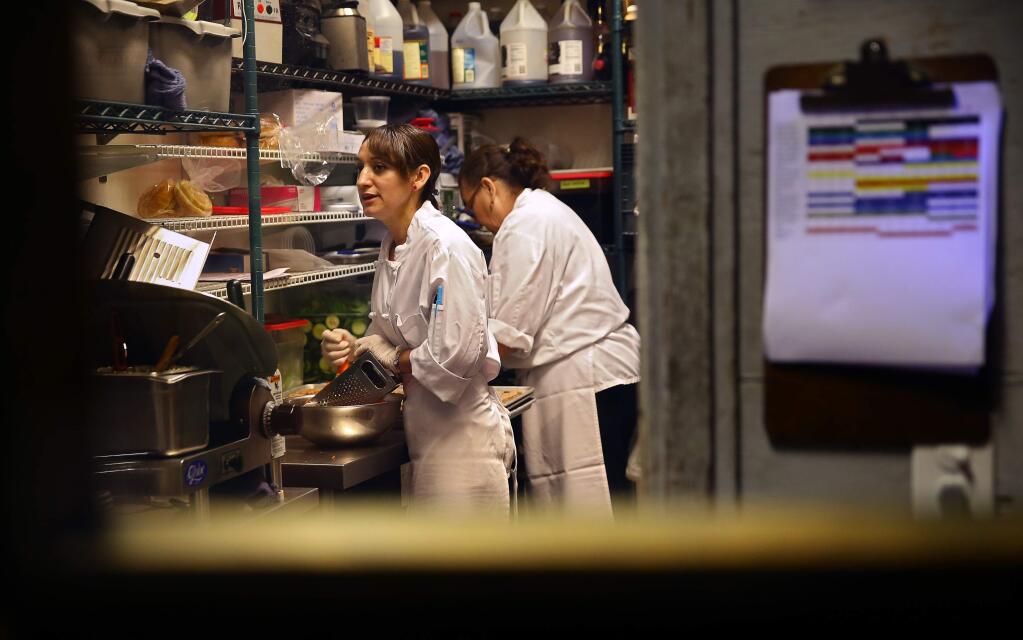 Veronica Mondragon, left, and Consuelo Sandoval prep ingredients in the back of Healdsburg Bar & Grill, in Healdsburg, on Monday, June 22, 2015. The restaurant is voluntarily increasing wages to $15 per hour, starting July 1.(Christopher Chung/ The Press Democrat)
