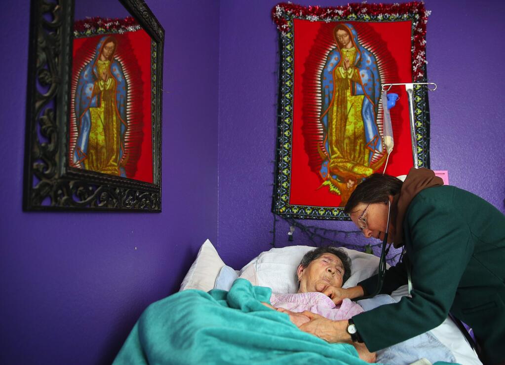 Jenny Shipp, right, a family nurse practitioner with the House Calls program of St. Joseph Health-Sonoma County, checks the vital signs of 92-year-old Paula Cuevas, at her home in Santa Rosa, on Wednesday, January 13, 2016. Cuevas has been seen by the House Calls program since 2009.(Christopher Chung/ The Press Democrat)