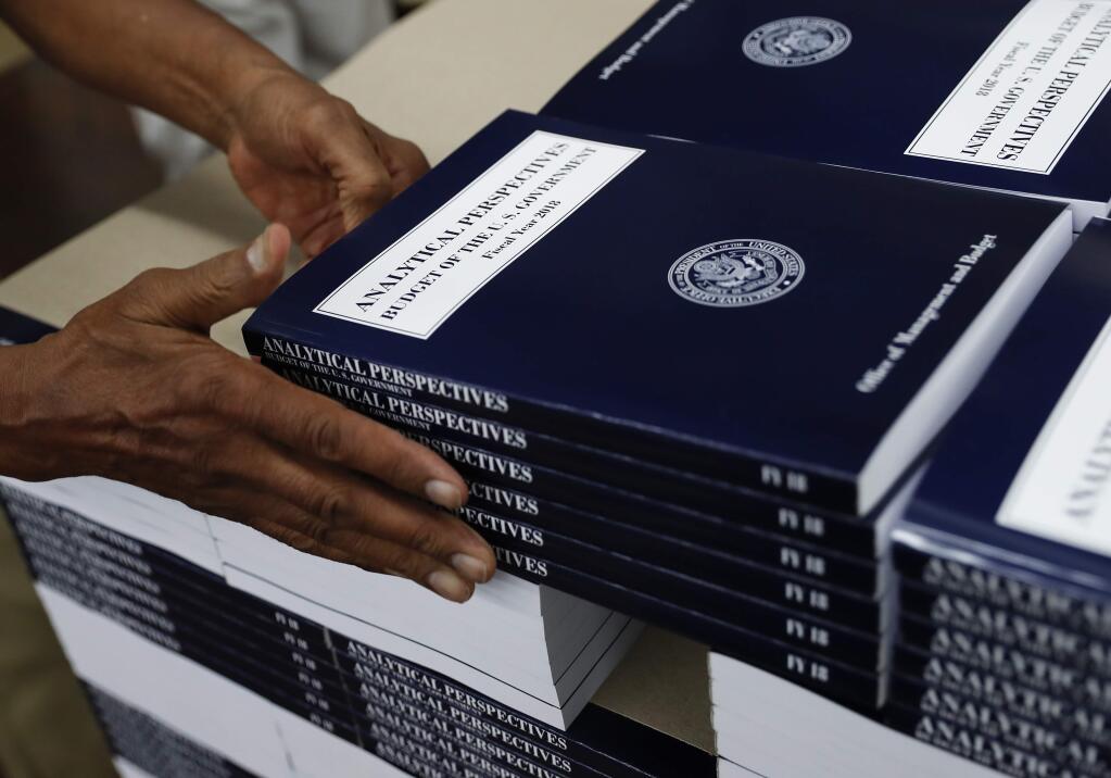 In this photo taken May 19, 2017, a GPO worker stacks copies of 'Analytical Perspectives Budget of the U.S. Government Fiscal Year 2018' onto a pallet at the U.S. Government Publishing Office's (GPO) plant in Washington. (AP Photo/Carolyn Kaster)