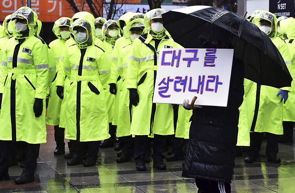 A protester holds a sign to denounce government's coronavirus responses in Daegu, South Korea, Tuesday, Feb. 25, 2020. China and South Korea on Tuesday reported more cases of a new viral illness that has been concentrated in North Asia but is causing global worry as clusters grow in the Middle East and Europe. The signs read 'Save Daegu.'(Lee Moo-ryul/Newsis via AP)
