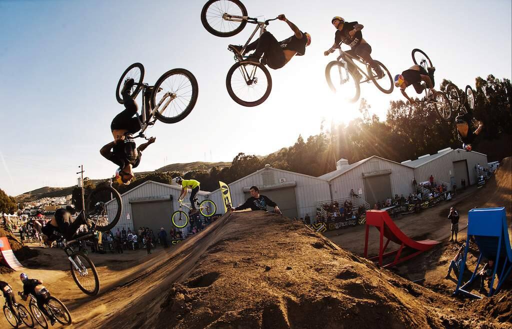 A demonstration of the athleticism and acrobatic skills that can lead to victory at a pro mountain bike competition: Andreu Lacondeguy, center, does a double backflip to clinch a victory.