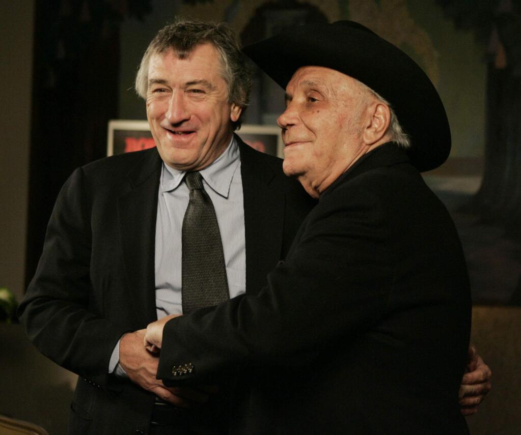 FILE - In this Jan. 27, 2005, file photo, Robert DeNiro, left, and boxer Jake LaMotta stand for photographers before watching a 25th anniversary screening of the movie 'Raging Bull' in New York. LaMotta, whose life was depicted in the film “Raging Bull,” died Tuesday, Sept. 19, 2017, at a Miami-area hospital from complications of pneumonia. He was 95. (AP Photo/Julie Jacobson, File)