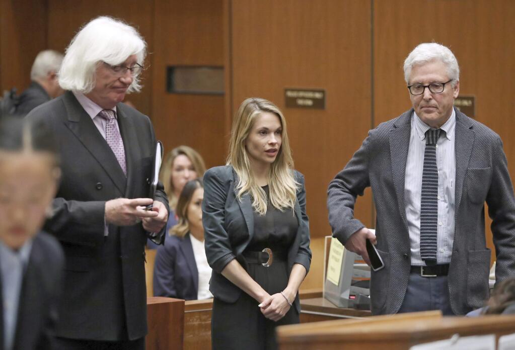 Model and Playboy bunny Danielle 'Dani' Mathers, center, answers the judges's questions with her attorneys Tom Mesereau, left, and Dana M. Cole Wednesday, May 24, 2017, to answer charges related to her taking a photo of a naked, 71-year-old woman in a gym locker room and posting it on social media with insults about the woman's body, in Los Angeles County Superior Court in Los Angeles. She pleaded no contest and was sentenced to probation and 30 days of community service. (Frederick M. Brown/Pool photo via AP)