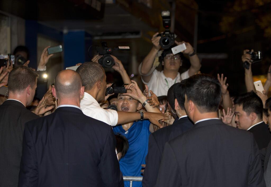 President Barack Obama, surrounded by security, greets the crowd outside the Bún ch? Huong Liên restaurant after having dinner with American Chef Anthony Bourdain, Monday, May 23, 2016, in Hanoi, Vietnam. (AP Photo/Carolyn Kaster)