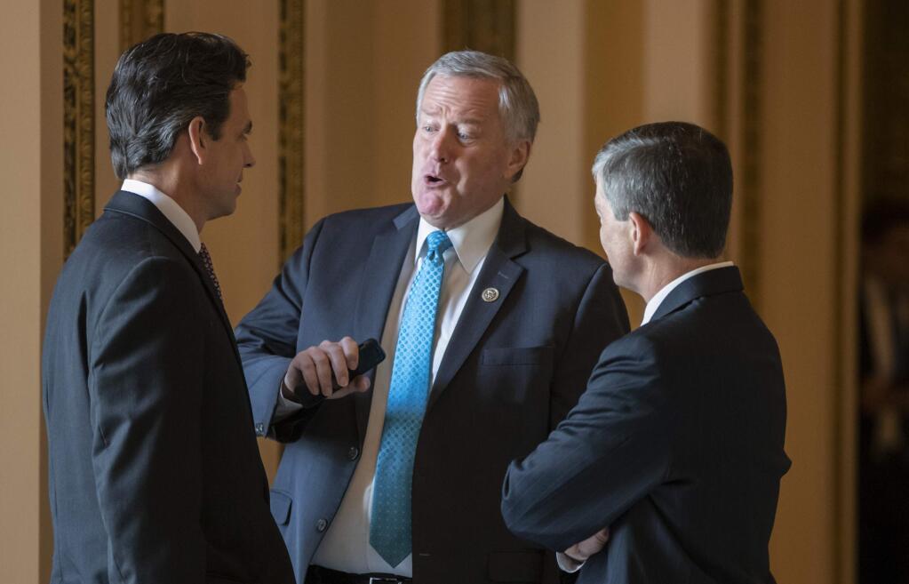 Rep. Mark Meadows, R-N.C., center, chairman of the conservative House Freedom Caucus, flanked by Rep. Tom Graves, R-Ga., Rep. Jeb Hensarling, R-Texas, talk before a series of votes in the House, at the Capitol in Washington, Thursday, June 21, 2018. Yesterday, Rep. Meadows and Speaker of the House Paul Ryan, R-Wis., faced off in the chamber as lawmakers struggled to move on immigration amid the political fallout of migrant families being separated at the border. (AP Photo/J. Scott Applewhite)