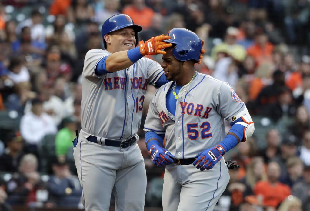 The New York Mets' Asdrubal Cabrera, left, takes the helmet off teammate Yoenis Cespedes (52) after Cespedes' two-run home run against the San Francisco Giants during the second inning Friday, June 23, 2017, in San Francisco. (AP Photo/Marcio Jose Sanchez)