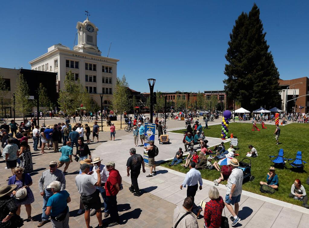People walk around the grassy area in the center of the reunified Old Courthouse Square, in Santa Rosa, California, on Saturday, April 29, 2017. (ALVIN JORNADA/ PD)