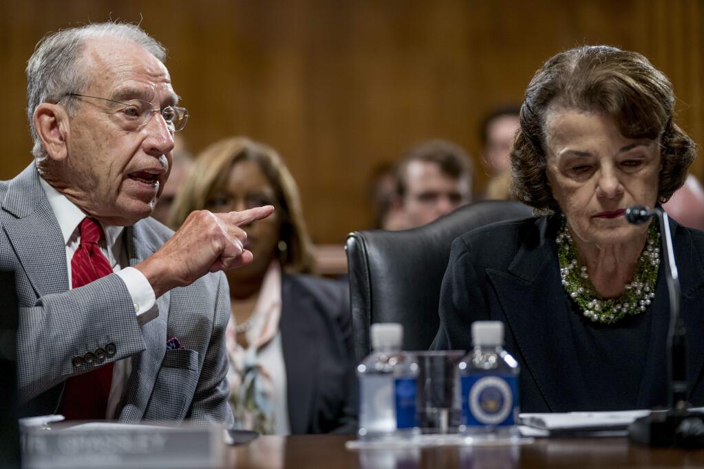 Senate Judiciary Committee Chairman Chuck Grassley, R-Iowa, left, accompanied by Sen. Dianne Feinstein, D-Calif., the ranking member, right, speaks during a Senate Judiciary Committee markup meeting on Capitol Hill, Thursday, Sept. 13, 2018, in Washington. The committee will vote next week on whether to recommend President Donald Trump's Supreme Court nominee, Brett Kavanaugh for confirmation. Republicans hope to confirm him to the court by Oct. 1.(AP Photo/Andrew Harnik)