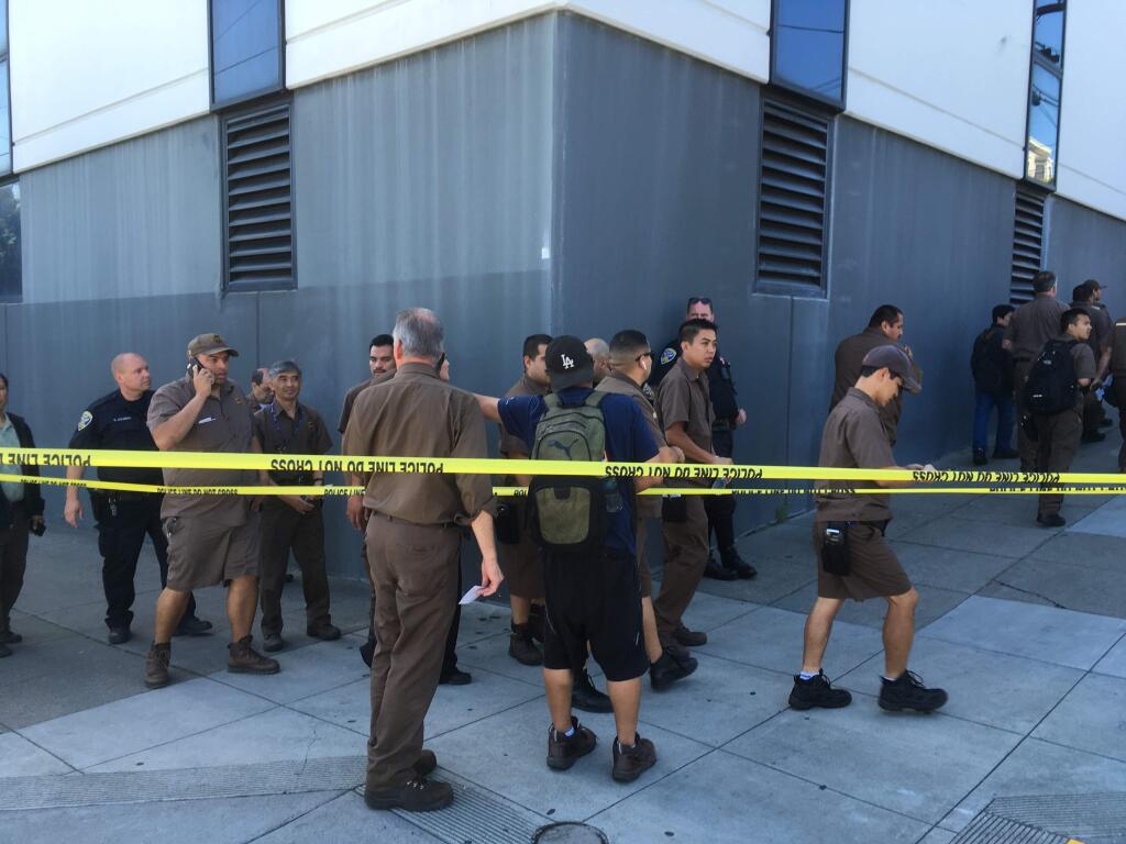 UPS workers gather outside after a shooting at a UPS warehouse and customer service center in San Francisco on Wednesday, June 14, 2017. (AP Photo/Eric Risberg)