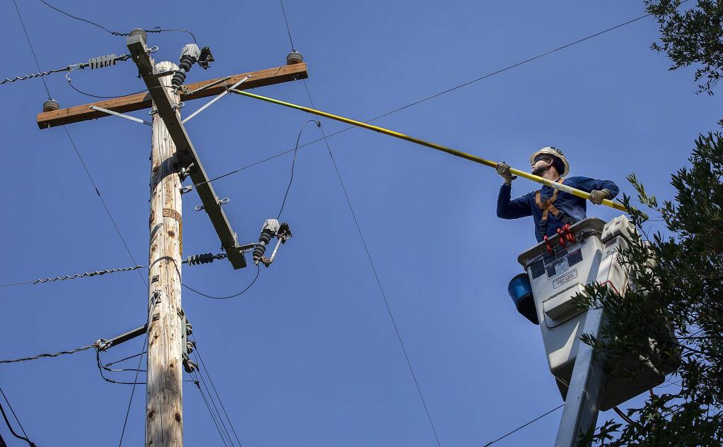 After checking homes along Adobe Canyon Road near the entrance to Sugarloaf State Park, PG&E lineman Jake Southard disconnects subsidiary power for a few isolated homes so they can reenergize the lines for the majority of customers more quickly on Oct. 11, 2019. (John Burgess/The Press Democrat)