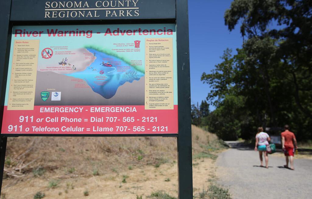 A sign at Sunset Beach near Forestville warns visitors about the dangers of swimming in the Russian River. (CHRISTOPHER CHUNG / The Press Democrat)
