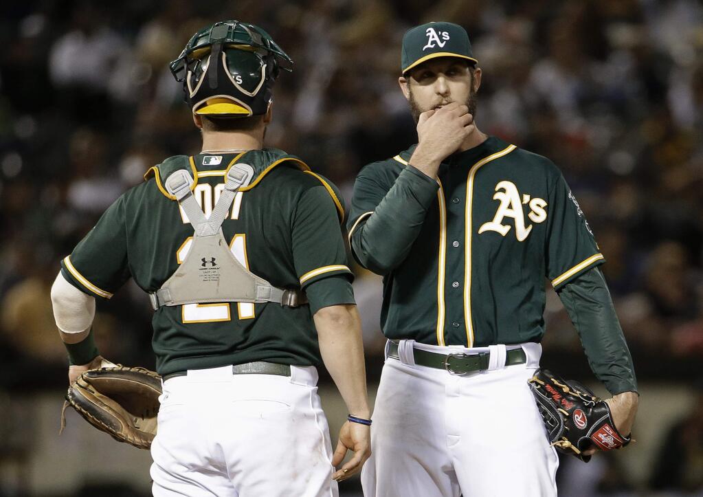 Oakland Athletics pitcher Cody Martin, right, stands on the mound with catcher Stephen Vogt before being taken out for a relief pitcher during the fourth inning of a baseball game against the Los Angeles Angels in Oakland, Calif., Tuesday, Sept. 1, 2015. (AP Photo/Jeff Chiu)