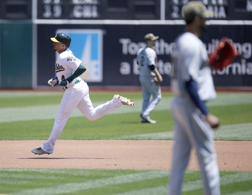 Oakland Athletics Coco Crisp, left, rounds the bases after hitting a home run against Minnesota Twins pitcher Ervin Santana, right, in the first inning of a baseball game Monday, May 30, 2016, in Oakland, Calif. (AP Photo/Tony Avelar)