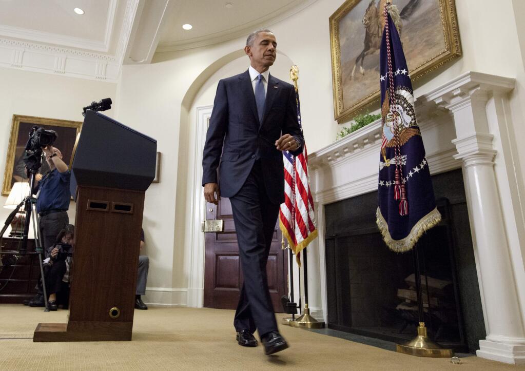 President Barack Obama walk from the podium after speaking in the Roosevelt Room of the White House in Washington, Wednesday, June 24, 2015, about the completion of the Hostage Policy Review. The president is clearing the way for families of U.S. hostages to pay ransom to terror groups without fear of prosecution, as the White House seeks to address criticism from those whose loved ones have been killed in captivity. (AP Photo/Carolyn Kaster)