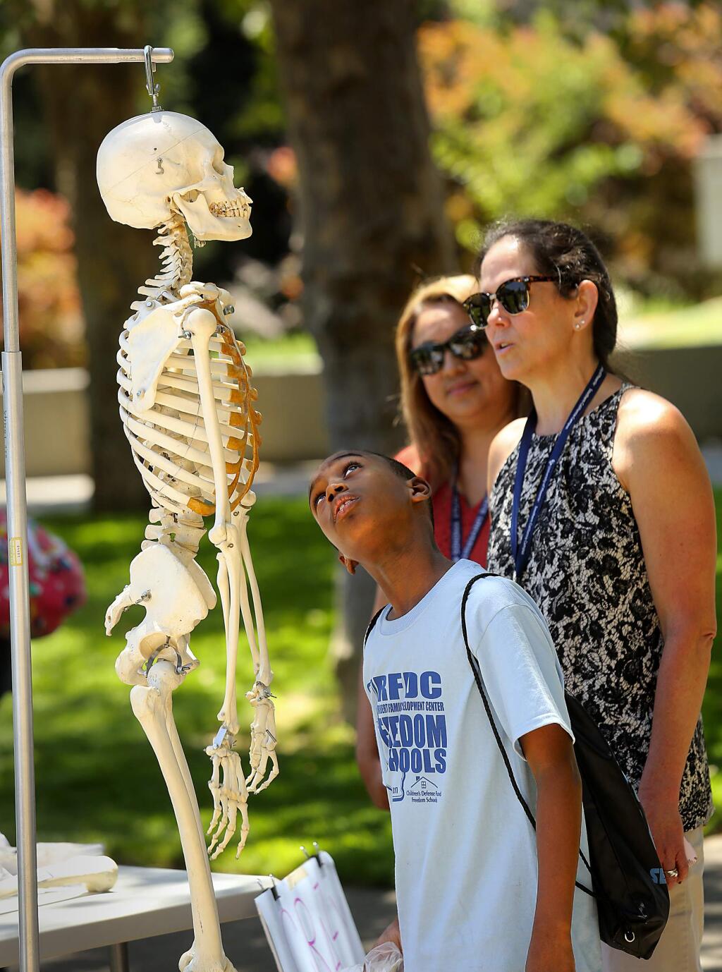 Marquise Hawthorne, 10, tries to identify the bones on a skeleton with Mary Ellen Wilkosz, far right, director of the Family Nurse Practitioner program at SSU. More than 400 kids from Sacramento's Roberts Family Development Center visited SSU to get a taste of college at 'I am the Future Day' on Thursday. (John Burgess/The Press Democrat)