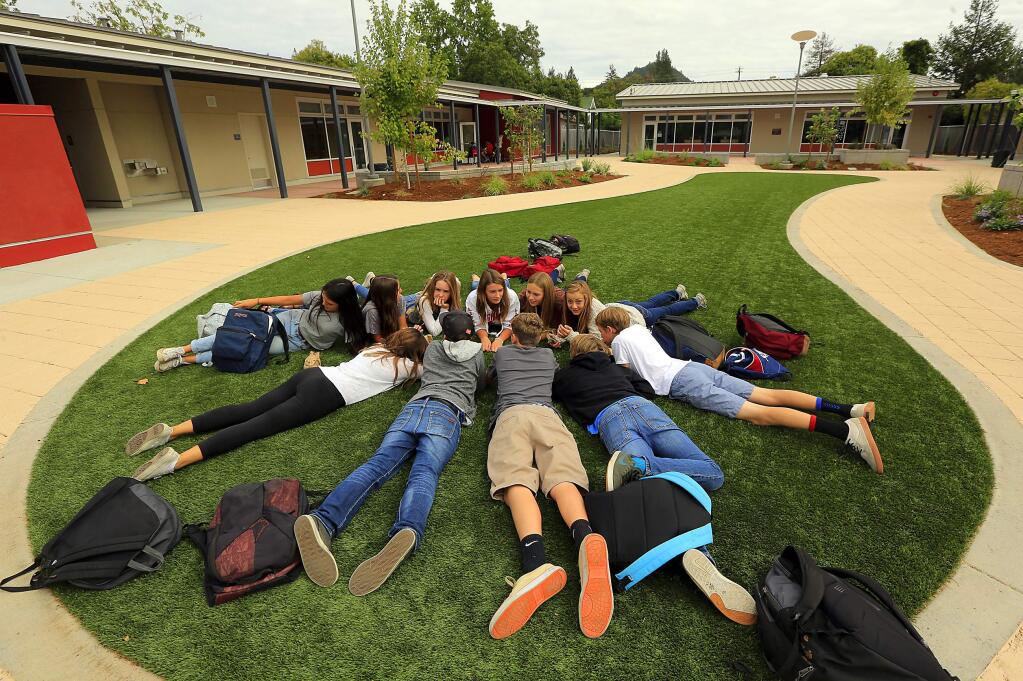 Seventh and eighth graders gather on the artificial grass for lunch in a area previously occupied by decrepit portable classrooms at Healdsburg Junior High School. (JOHN BURGESS / The Press Democrat)