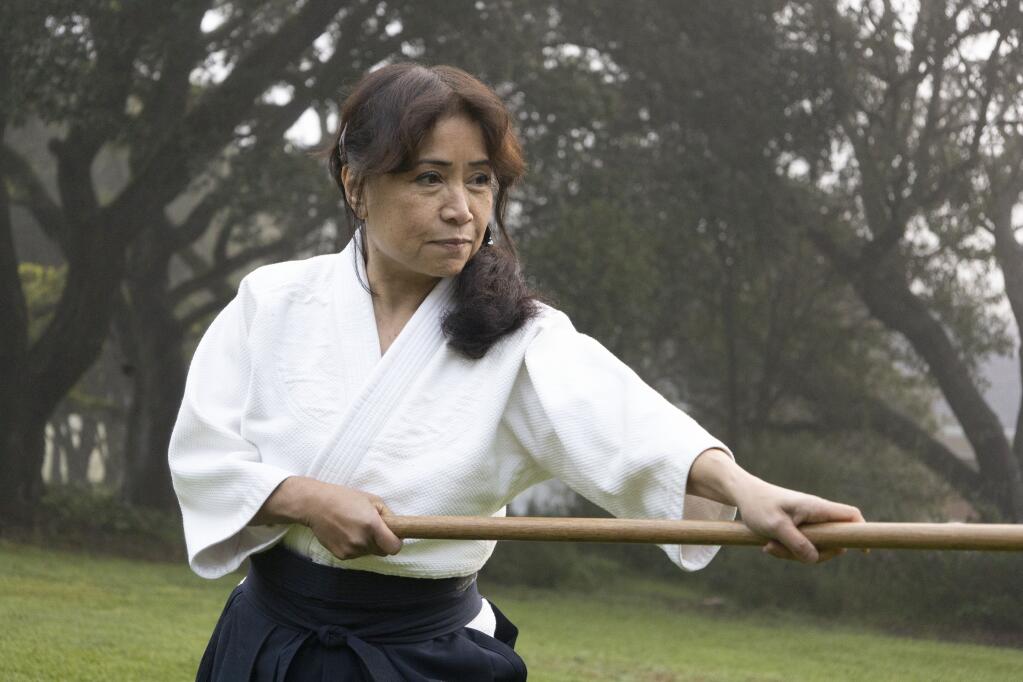 Ginny Breeland demonstrates an Aikido technique using a wooden weapon called bokken. (LINA HOSHINO/FOR THE ARGUS-COURIER)