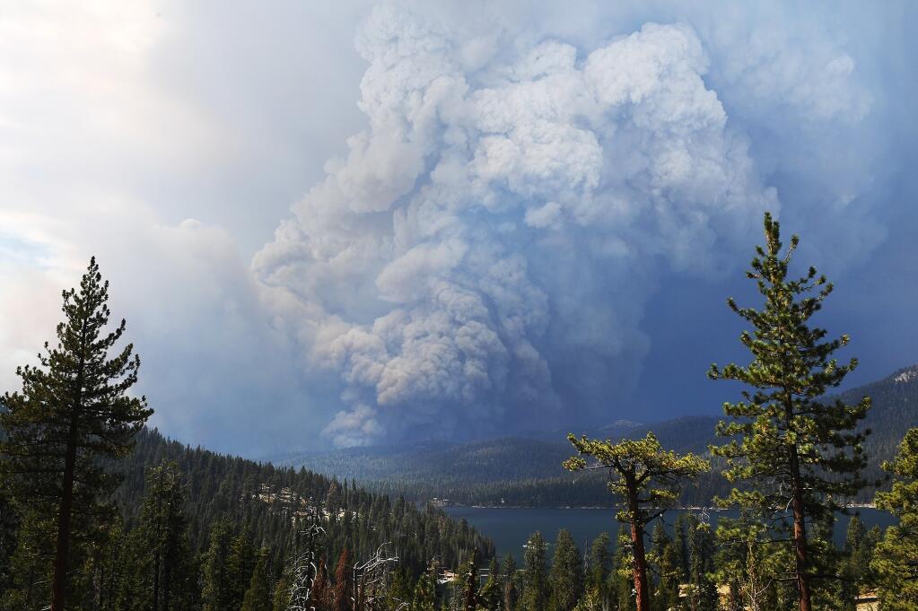 Plumes of smoke rise into the sky as a wildfire burns on the hills near Shaver Lake, Calif., Saturday, Sept. 5, 2020. Fires in the Sierra National Forest have prompted evacuation orders as authorities urged people seeking relief from the Labor Day weekend heat wave to stay away from the popular lake. (Eric Paul Zamora/The Fresno Bee via AP)