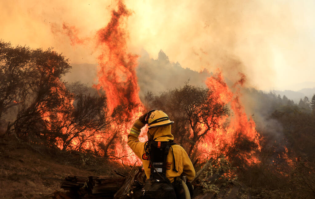 Cal Fire's Cristina Ramirez prepares to douse flames on the Glass fire on Sharp Road near Petrified Forest Road in Sonoma County west of Calistoga, Wednesday, Sept. 30, 2020(Kent Porter / The Press Democrat) 2020